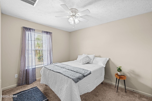 bedroom with a textured ceiling, ceiling fan, carpet flooring, visible vents, and baseboards