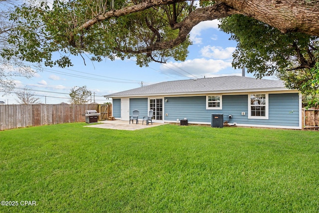 rear view of house featuring a patio area, a fenced backyard, central AC unit, and a lawn