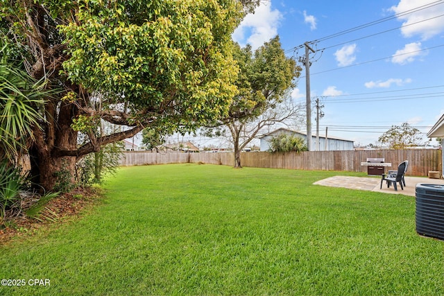 view of yard featuring a patio area, a fenced backyard, and central AC unit