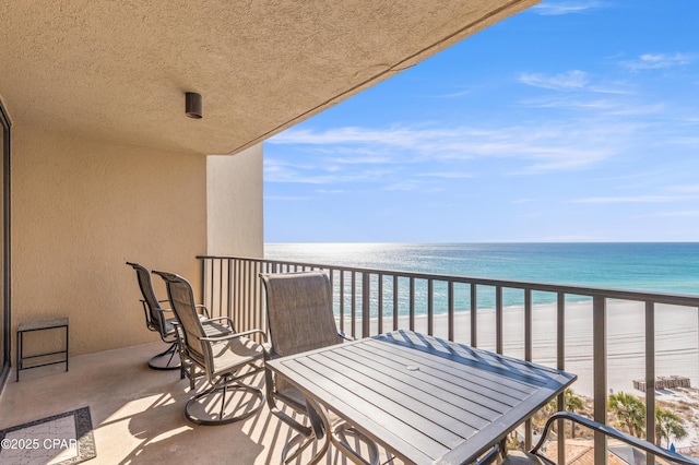 balcony featuring a water view and a beach view