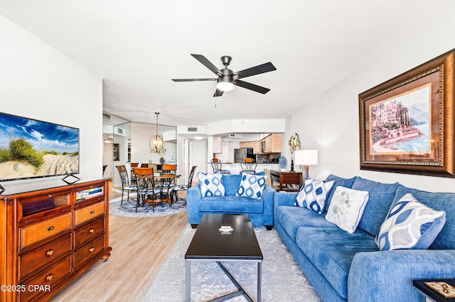 living room featuring light wood-type flooring and a ceiling fan