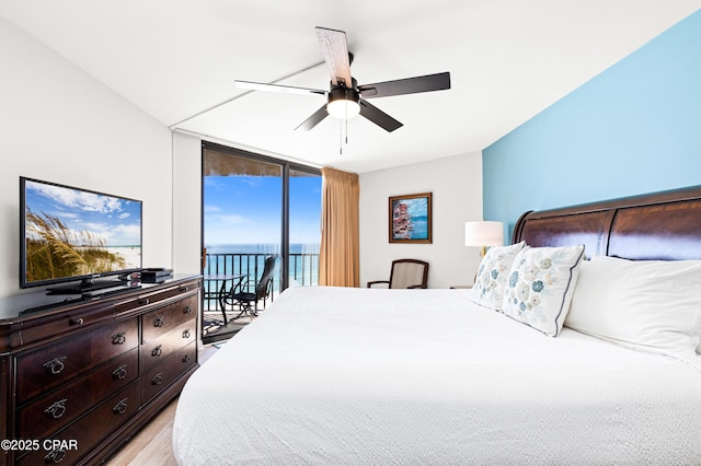 bedroom featuring access to exterior, floor to ceiling windows, light wood finished floors, and a ceiling fan