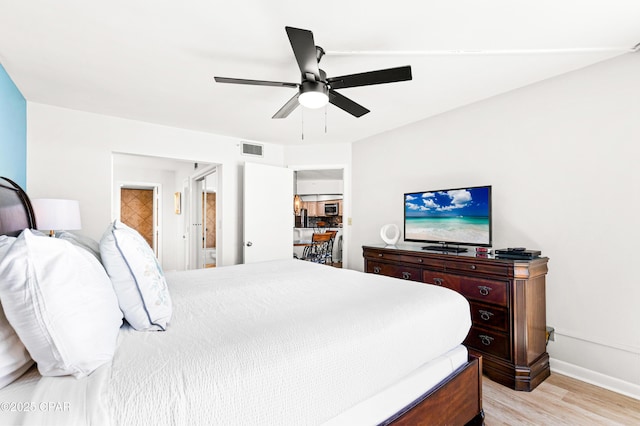 bedroom with baseboards, light wood-style flooring, visible vents, and a ceiling fan