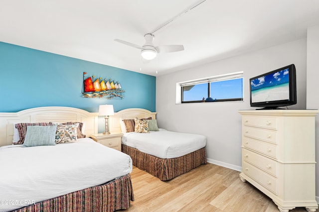 bedroom featuring baseboards, light wood-style flooring, and a ceiling fan