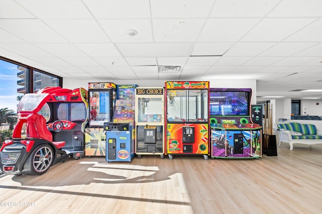 recreation room with visible vents, a drop ceiling, and wood finished floors