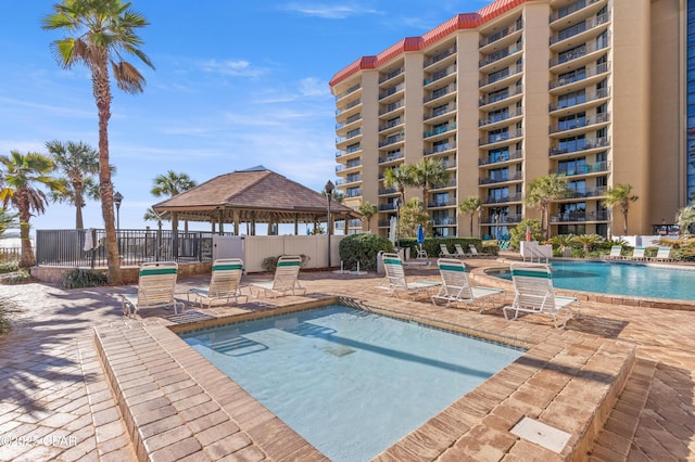 community pool featuring a gazebo, a patio area, and fence