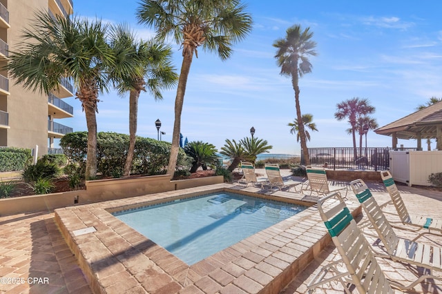 view of swimming pool with a patio, a swimming pool, and fence