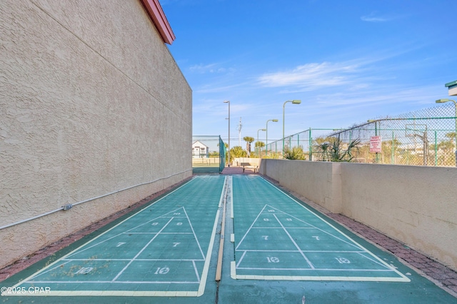 view of home's community featuring shuffleboard and fence