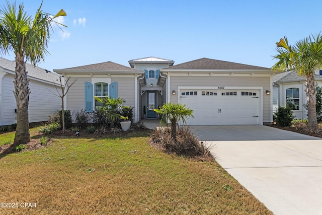 view of front of home featuring concrete driveway, an attached garage, and a front lawn