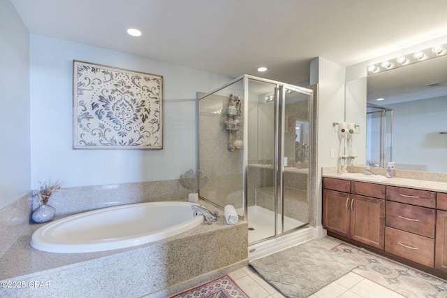 full bath with a stall shower, tile patterned flooring, a garden tub, and vanity