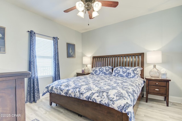 bedroom featuring wood finished floors, a ceiling fan, and baseboards