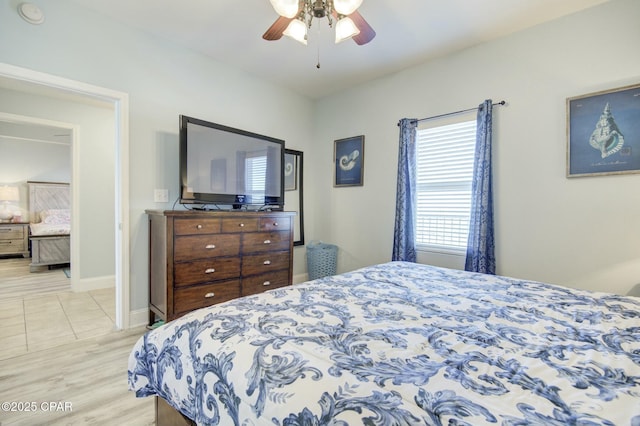 bedroom with a ceiling fan, light wood-type flooring, and baseboards