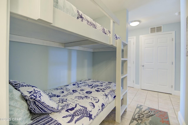 bedroom with tile patterned flooring, visible vents, and baseboards