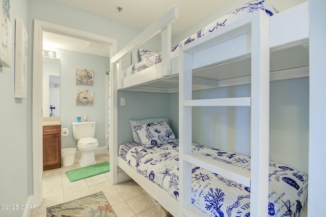 bedroom with connected bathroom and light tile patterned floors