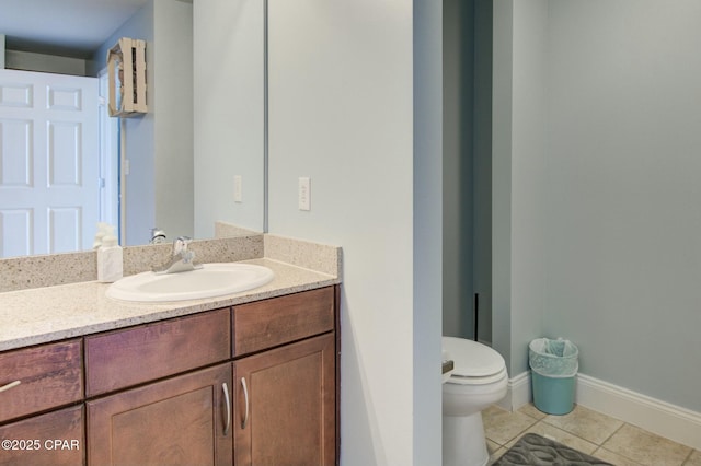 bathroom with tile patterned flooring, baseboards, vanity, and toilet