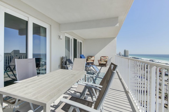 balcony with a view of the beach, a sunroom, and a water view