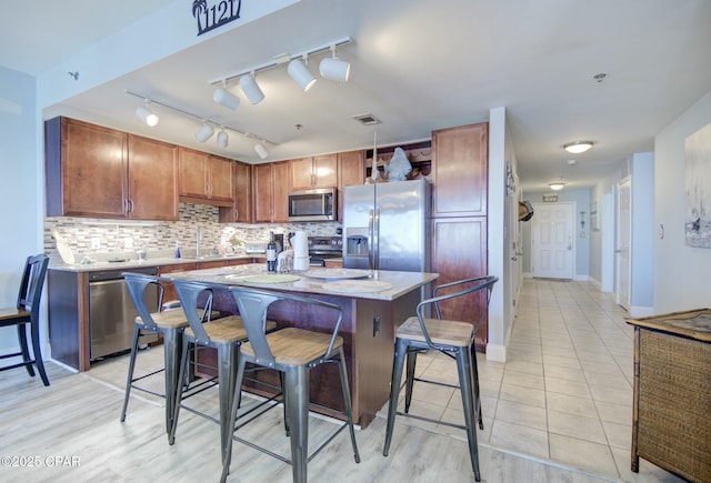 kitchen featuring tasteful backsplash, visible vents, appliances with stainless steel finishes, and light countertops