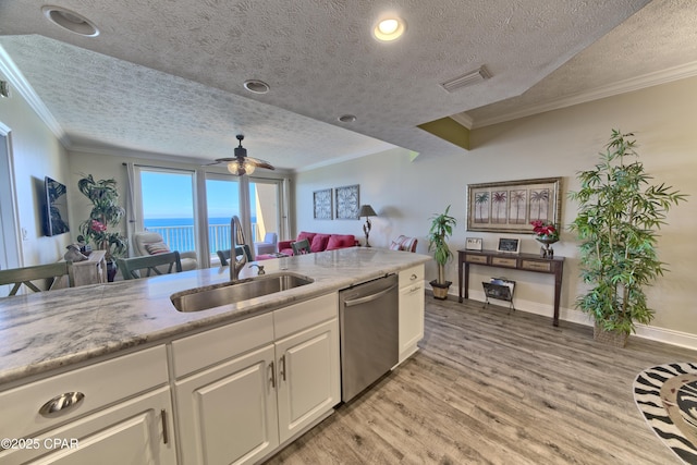 kitchen featuring a sink, visible vents, light wood-type flooring, dishwasher, and crown molding