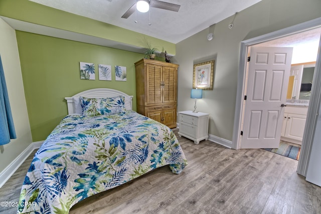 bedroom with a textured ceiling, light wood-type flooring, a ceiling fan, and baseboards