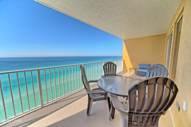 balcony with a water view and outdoor dining space