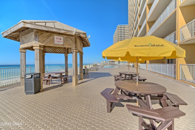 view of property's community featuring a view of the beach, a water view, and a gazebo