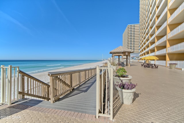 view of home's community with a water view, a beach view, and a gazebo