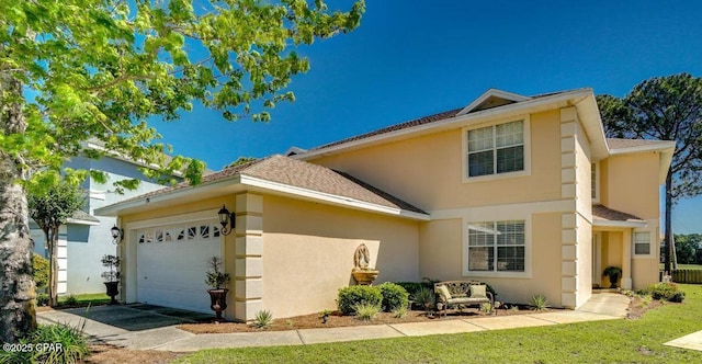 view of front of house featuring a shingled roof, driveway, an attached garage, and stucco siding