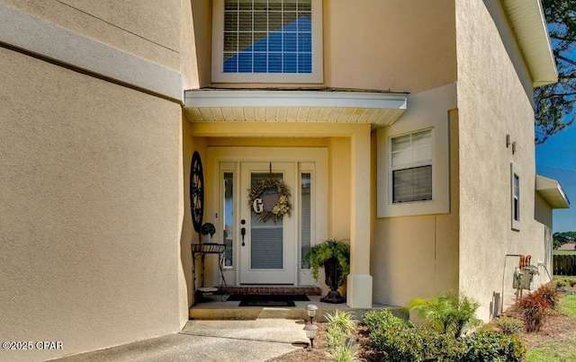 doorway to property featuring stucco siding