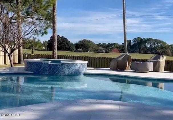 view of pool featuring a pool with connected hot tub and a fenced backyard