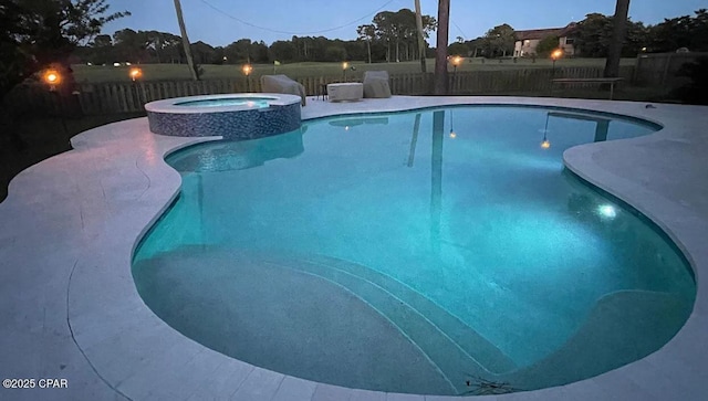 view of swimming pool featuring a fenced backyard and a pool with connected hot tub