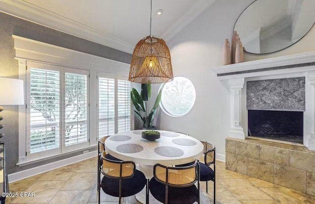 dining area featuring a fireplace, crown molding, baseboards, and light tile patterned flooring