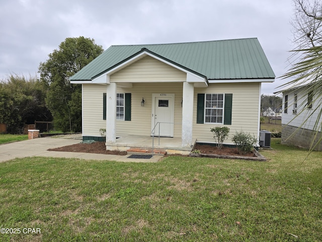 bungalow featuring metal roof, a front lawn, a porch, and cooling unit