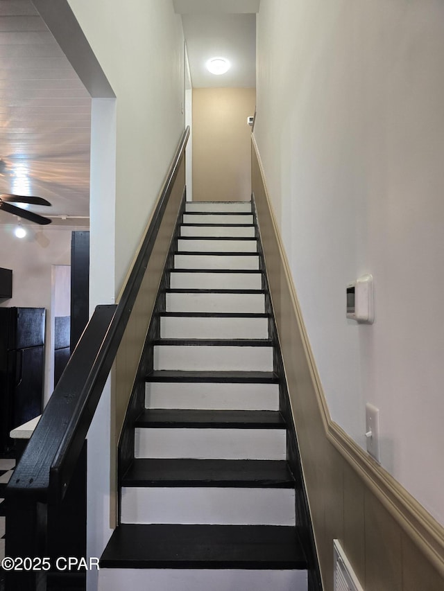 stairs featuring wainscoting