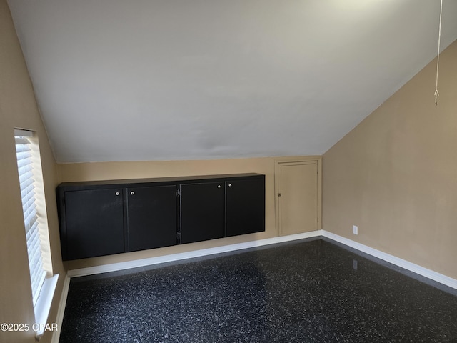 bonus room with vaulted ceiling and baseboards