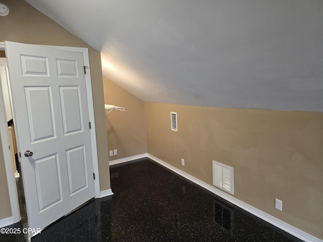 additional living space featuring lofted ceiling, visible vents, and baseboards