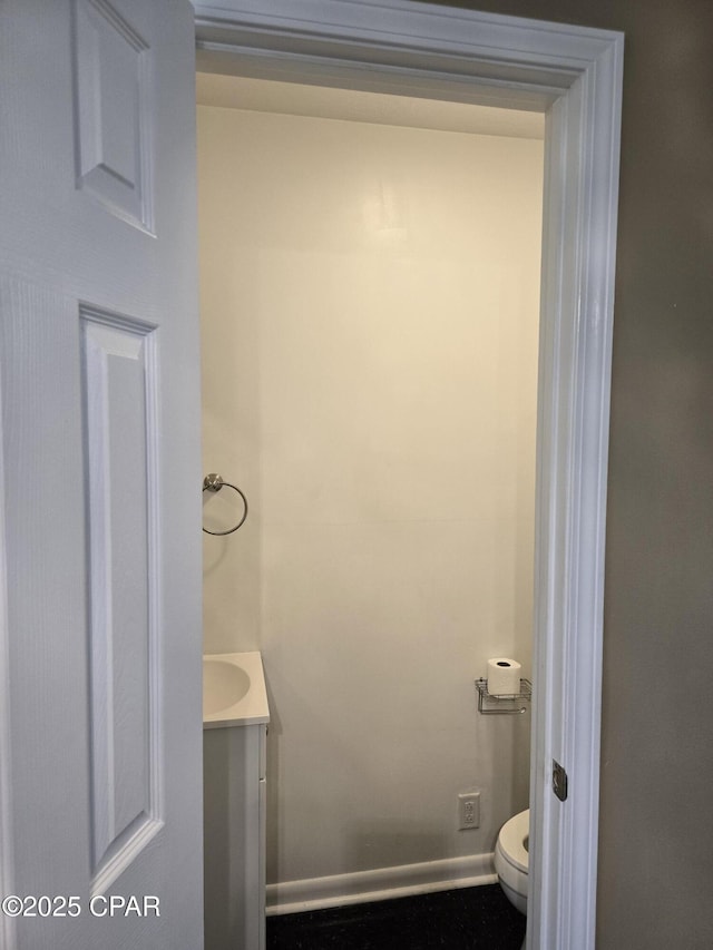 bathroom featuring vanity, toilet, and baseboards