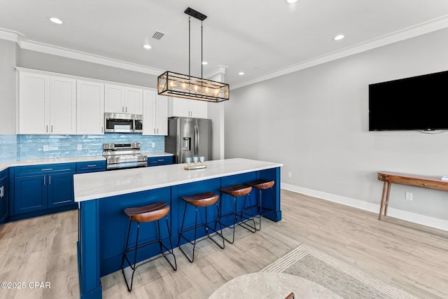 kitchen featuring blue cabinets, visible vents, appliances with stainless steel finishes, crown molding, and decorative backsplash