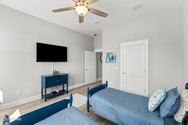 bedroom featuring ceiling fan, wood finished floors, visible vents, and baseboards