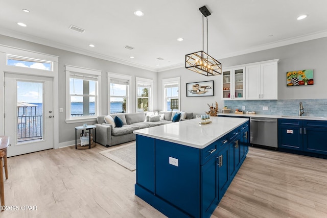 kitchen with blue cabinetry, a sink, decorative backsplash, white cabinets, and stainless steel dishwasher