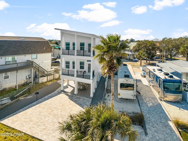 rear view of property featuring decorative driveway, a residential view, and a balcony