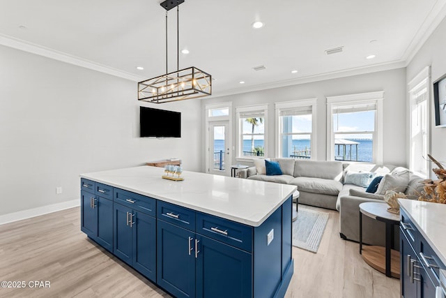 kitchen with crown molding, blue cabinets, and visible vents