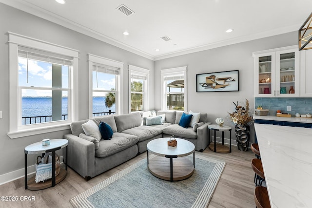 living room featuring baseboards, visible vents, recessed lighting, light wood-style floors, and crown molding