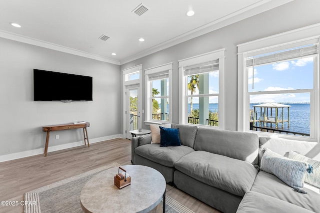 living room with visible vents, light wood-type flooring, crown molding, and baseboards