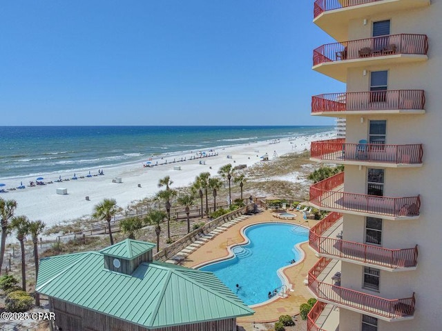 community pool with a water view and a beach view