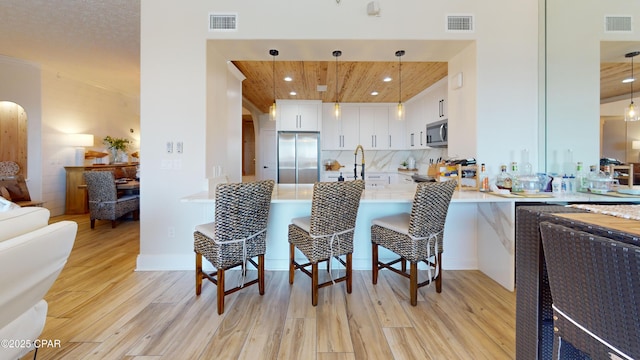 kitchen with stainless steel appliances, arched walkways, and visible vents