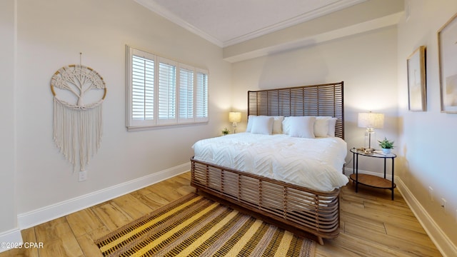 bedroom with light wood-style floors, ornamental molding, and baseboards