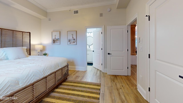 bedroom featuring ensuite bathroom, visible vents, baseboards, light wood-style floors, and crown molding