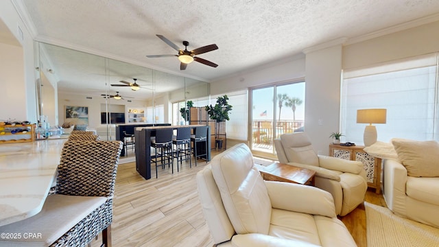 living room featuring light wood-style floors, a textured ceiling, and crown molding