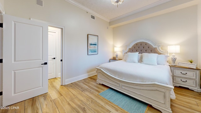 bedroom with light wood-style floors, visible vents, ornamental molding, and baseboards