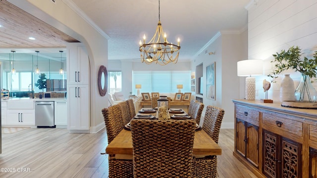 dining area featuring plenty of natural light, crown molding, and light wood-style flooring